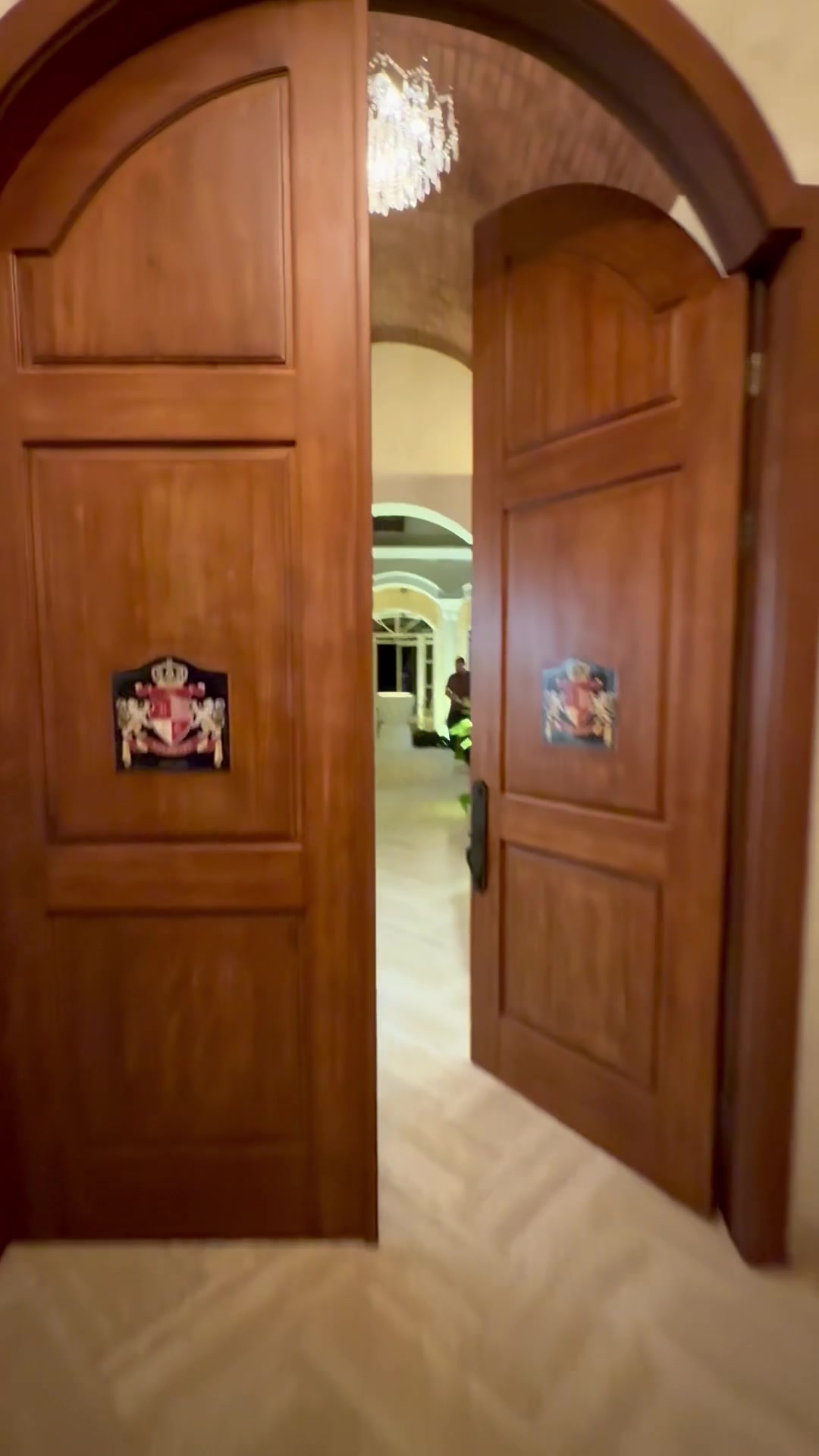 Grand arched entry doors with chandelier visible inside