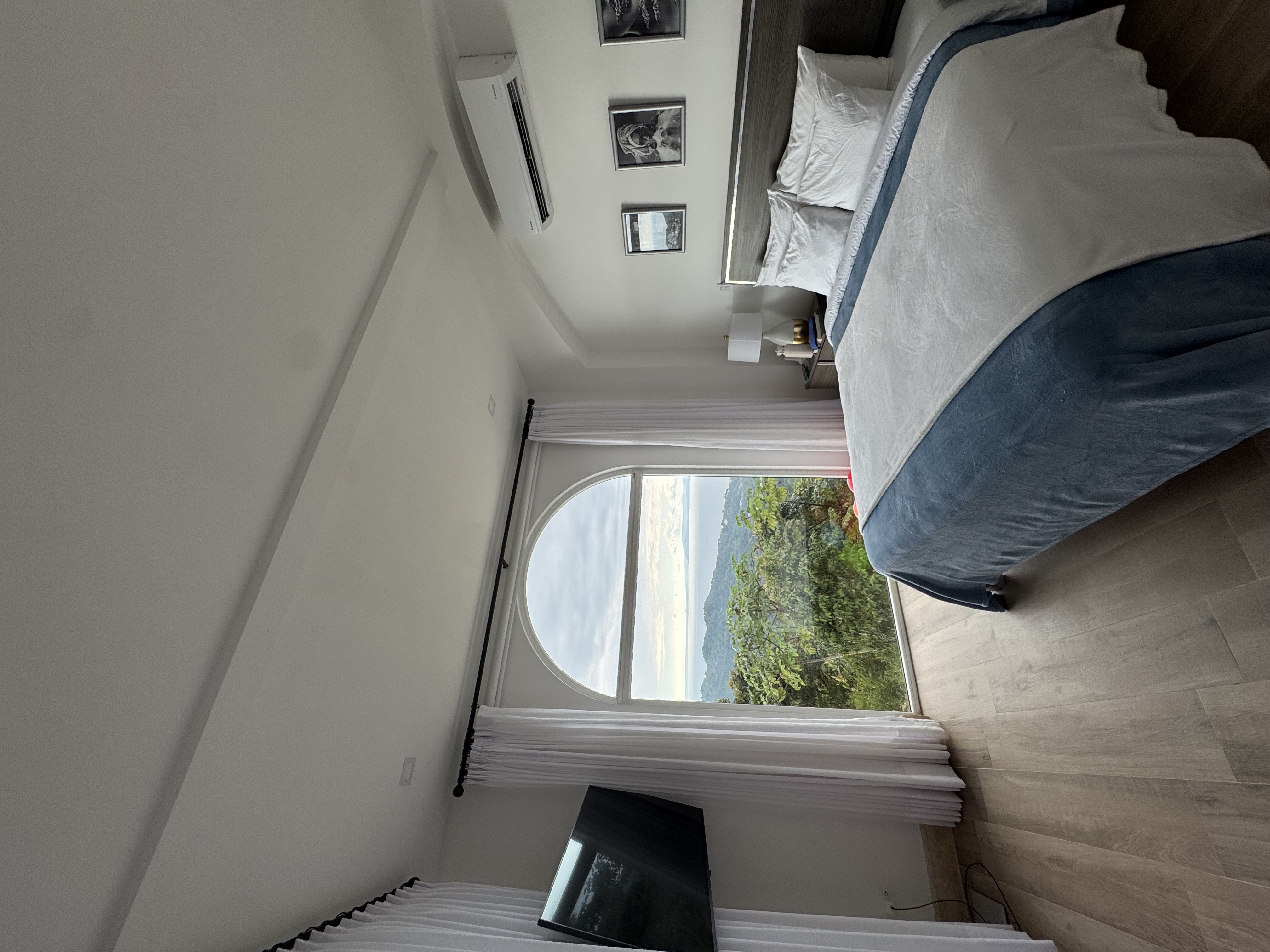 Bedroom with arched window and ocean view
